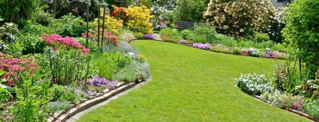 Garten mit Naturtsteinen zur Abgrenzung der Blumenbeete