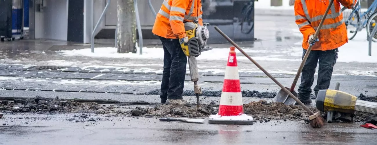 Zwei Arbeiter die eine Straße Reparieren.